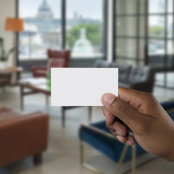 A printed business card held up in a styled interior
