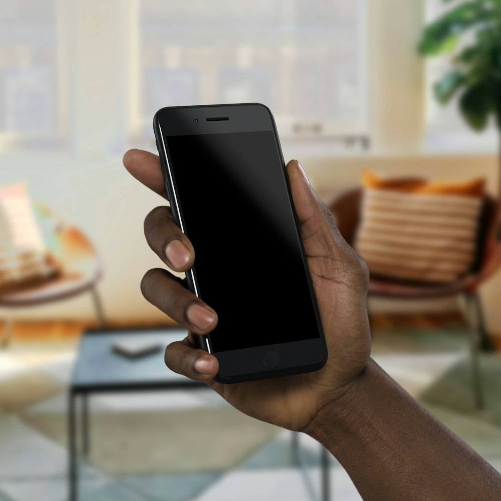 personne tenant un smartphone noir