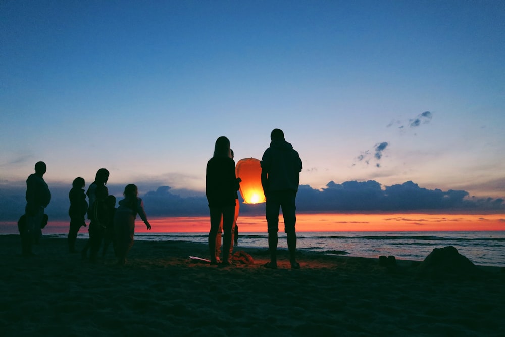 Silhouette einer Person, die eine Himmelslaterne hält