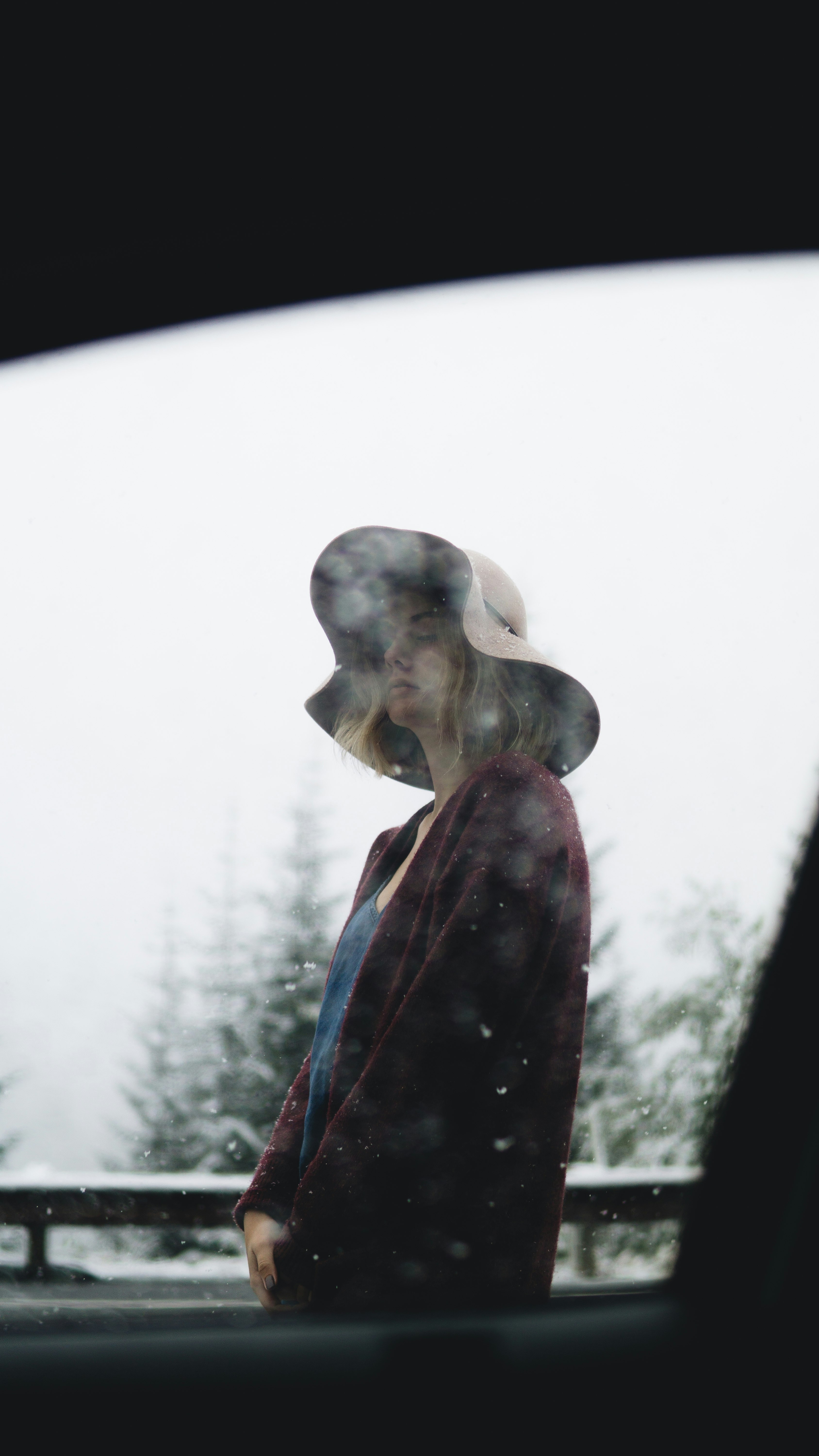 woman standing on snow near trees