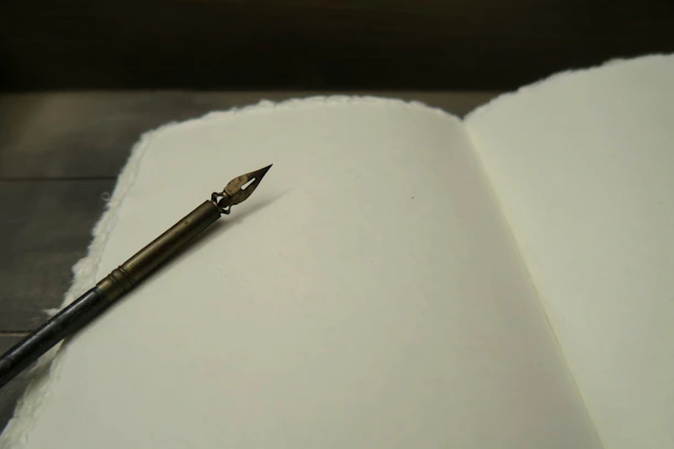 Close-up of an open book from the Inkspire series with handwritten notes and a vintage fountain pen resting on the page.