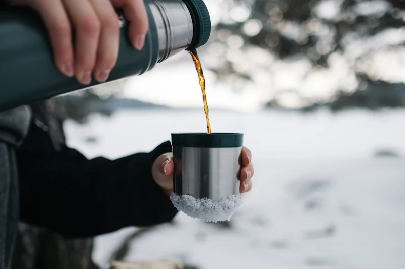 Persona sirviendo una bebida caliente en una taza