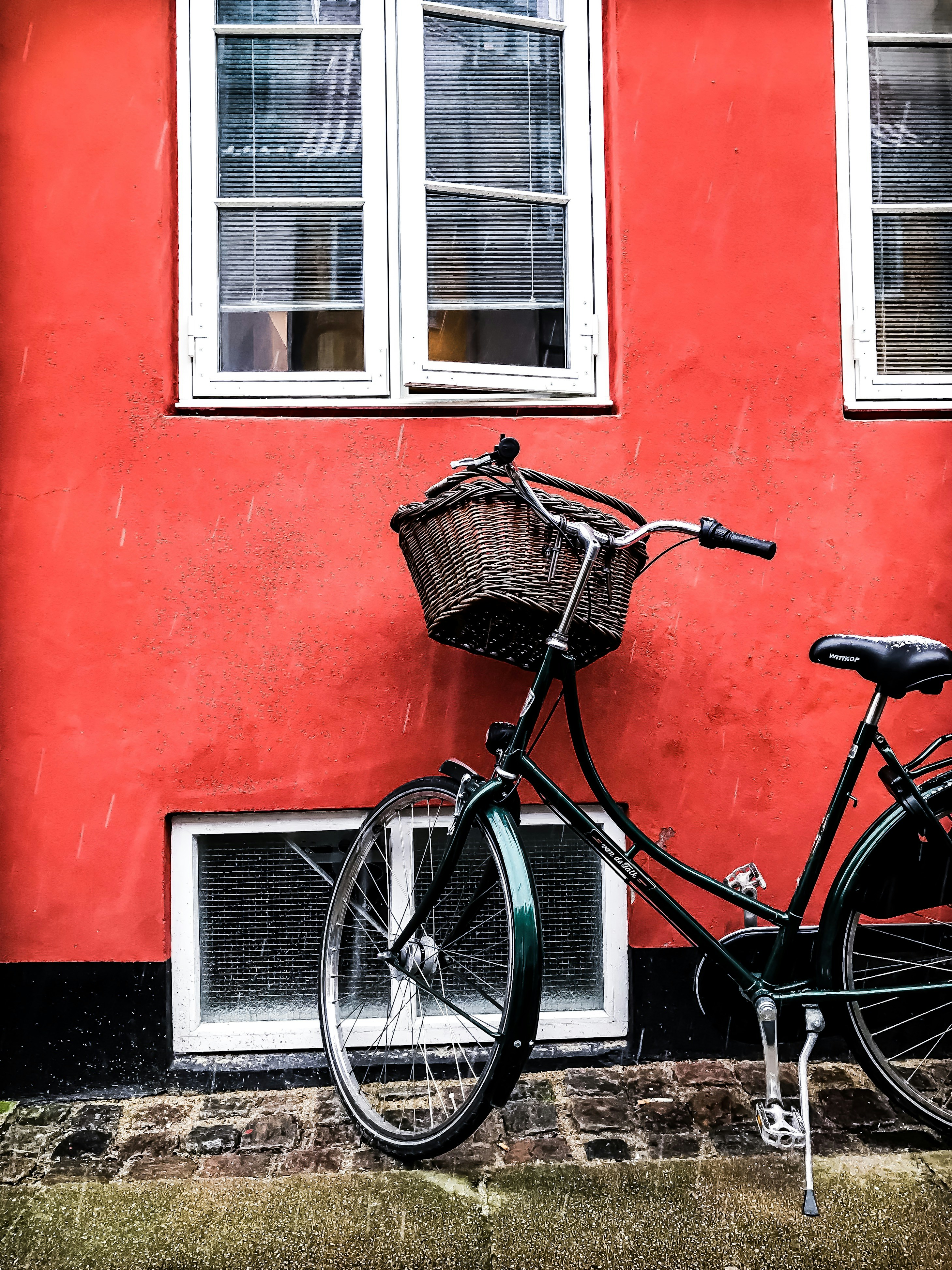 black cruiser bicycle beside red wall