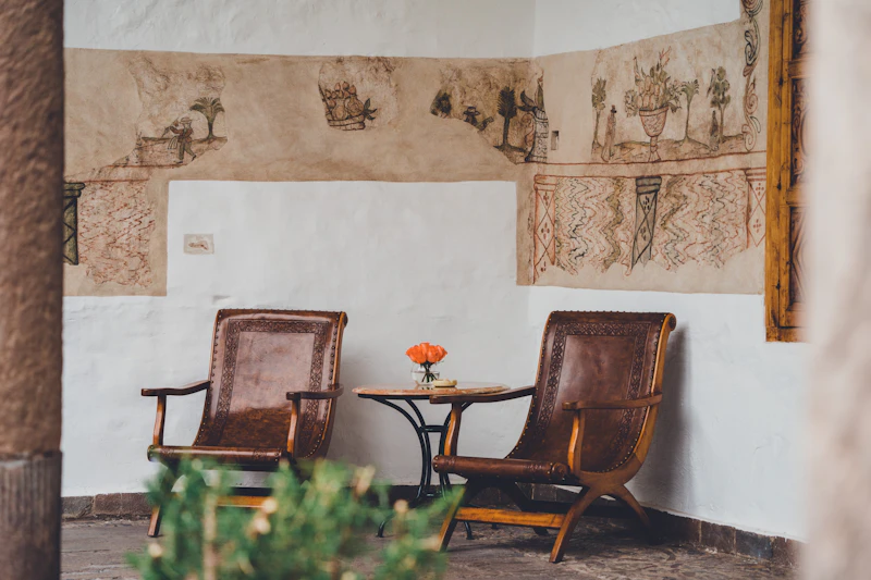 A quiet café corner with armchairs and a flower on the table in Cusco