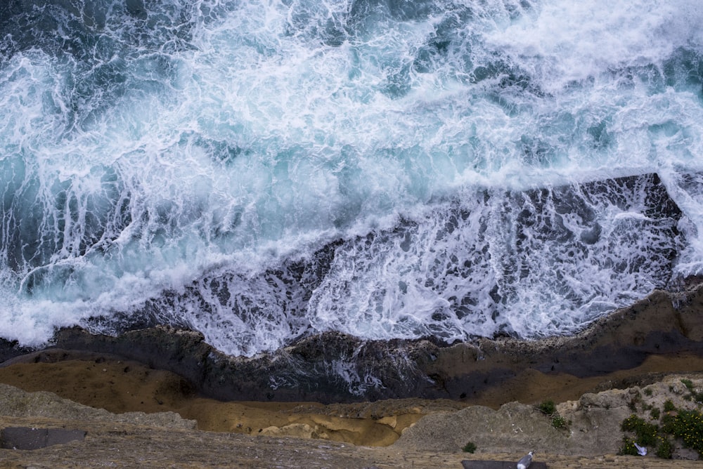 Vista aérea de las olas rompiendo contra las rocas