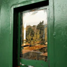 View from the window showing the olive green accents of the Ethimo restaurant’s outdoor seating.