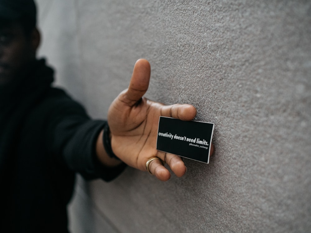 person holding black name plate