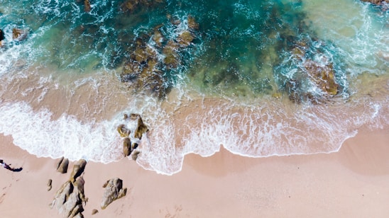 photo of sea waves crushing rocks