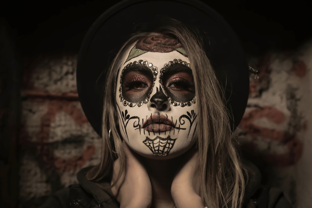 A woman with black and white makeup holding her hands to her face photo –  Halloween makeup Image on Unsplash