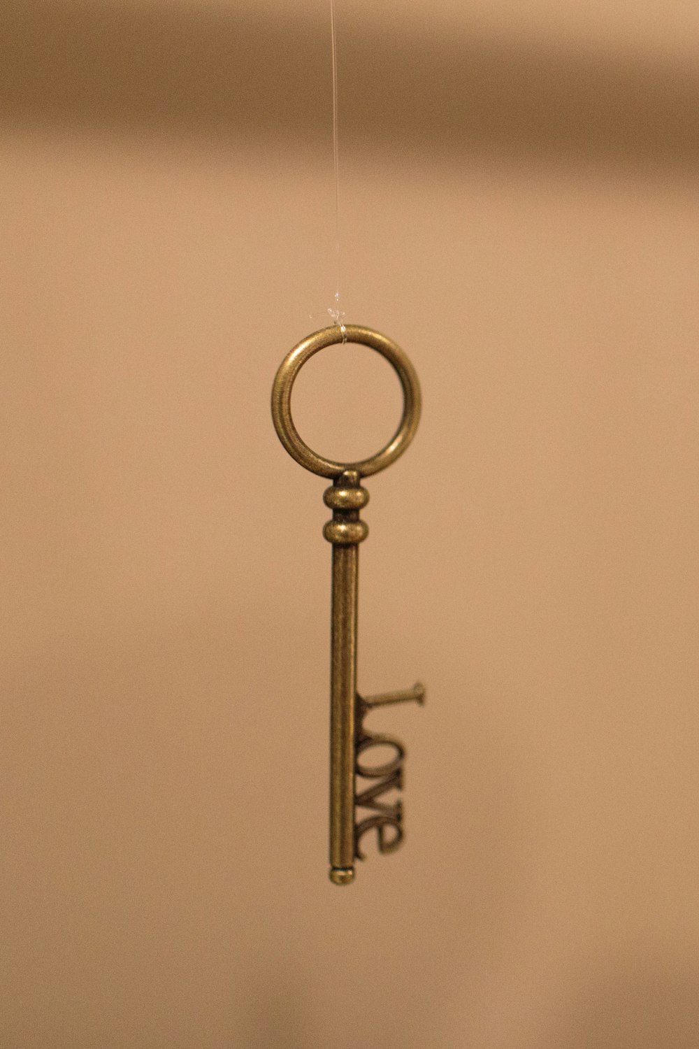 a golden key hanging from a hook on a wall