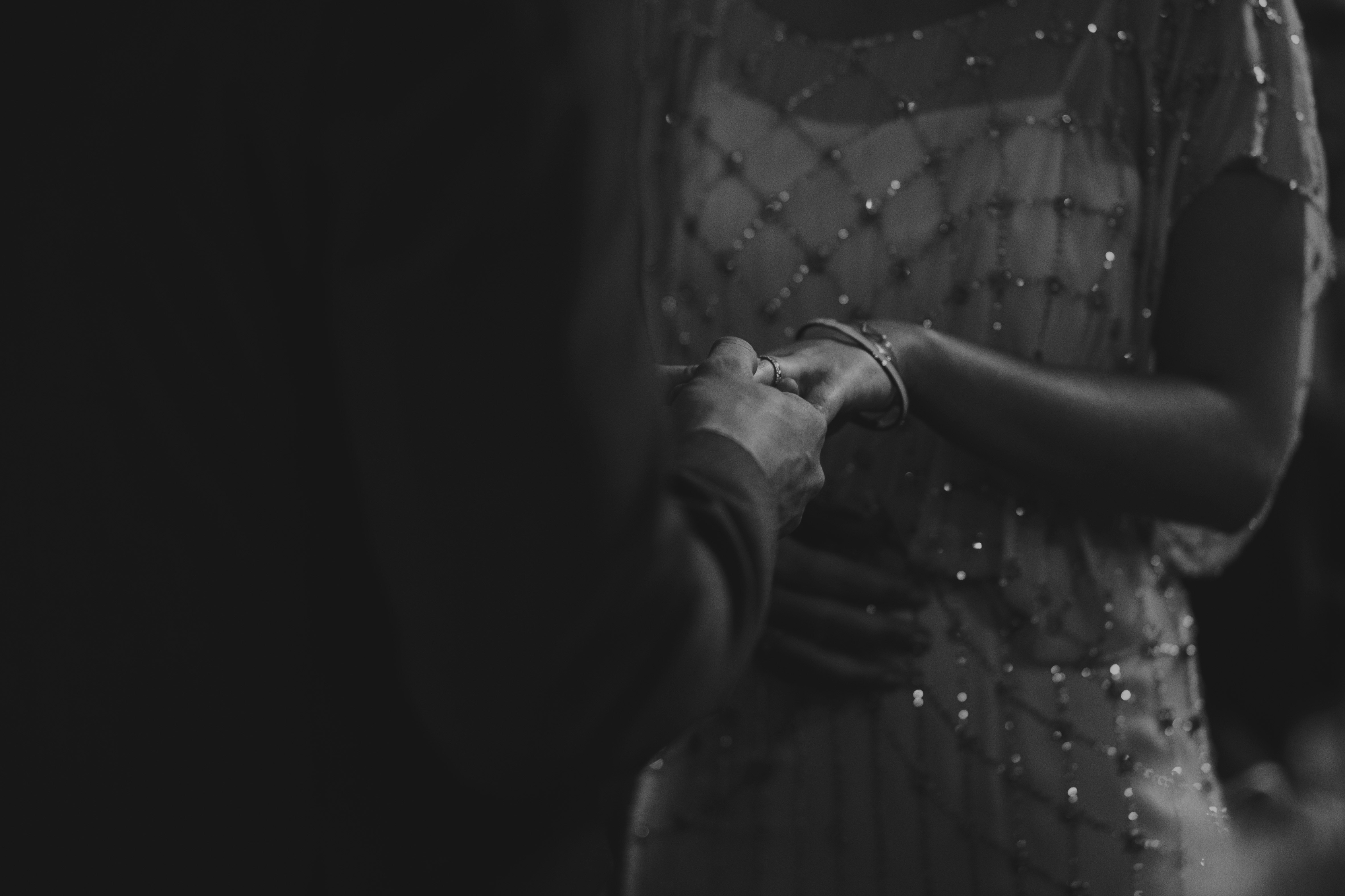 grayscale photo of woman holding man's hand