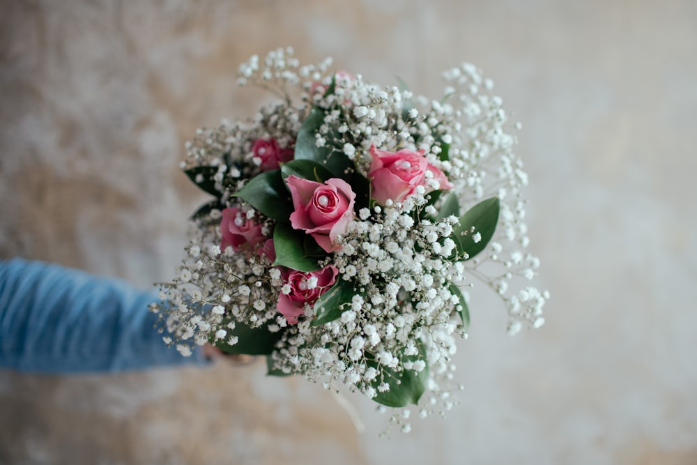 person holding pink flower bouquet