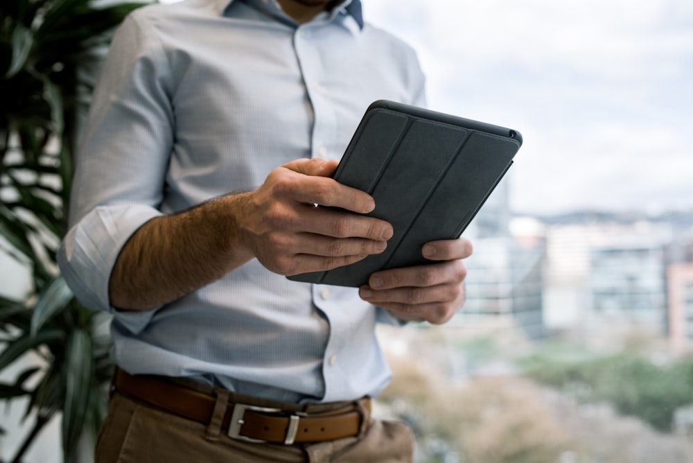 person holding black smart cover during daytime