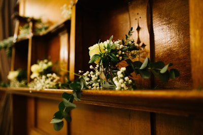 Close-up of decorative vases and candles arranged on a wooden shelf.
