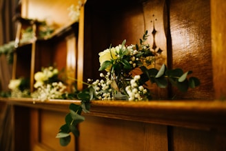 Close-up of decorative vases and candles arranged on a wooden shelf.