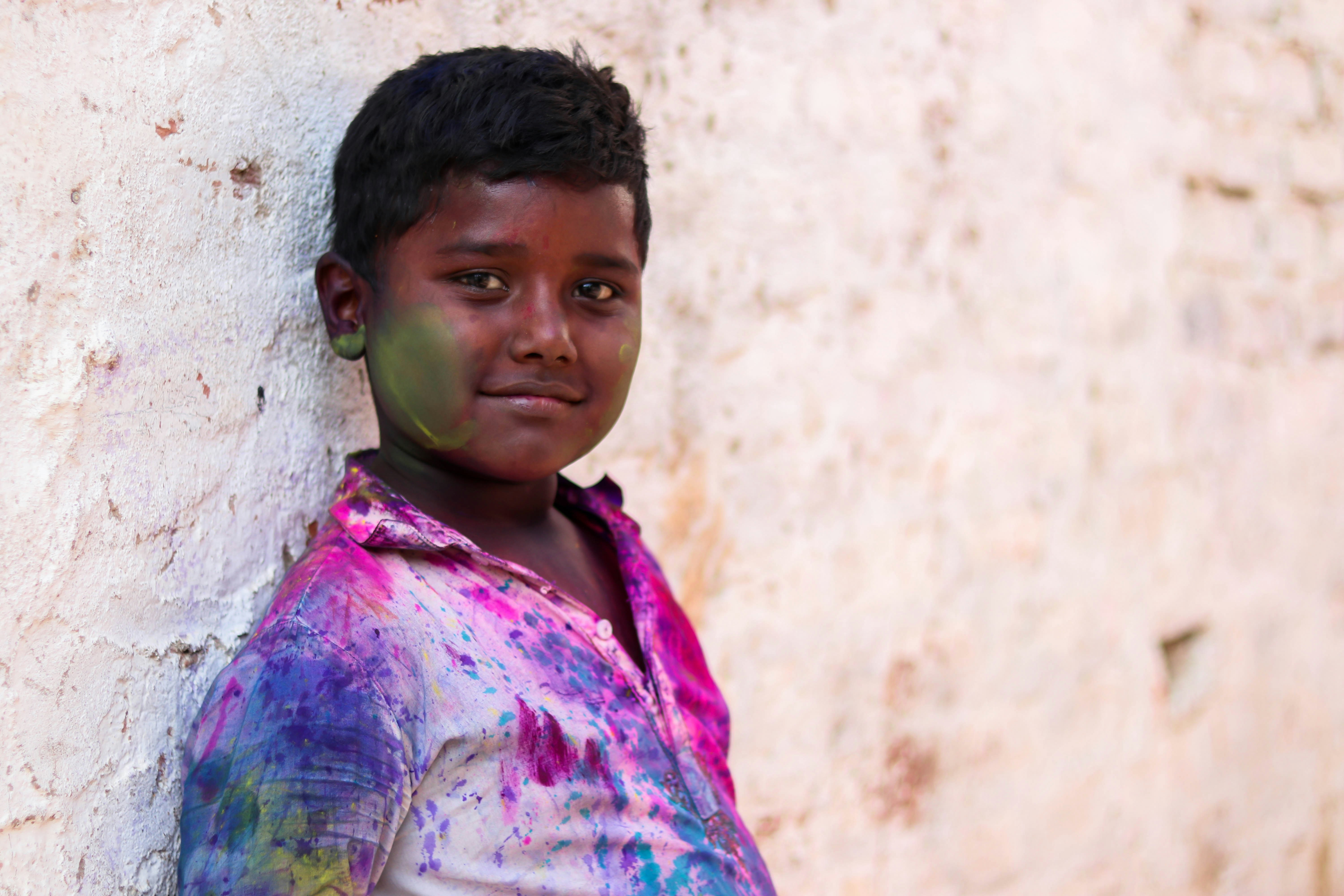 boy leaning on white wall at daytime