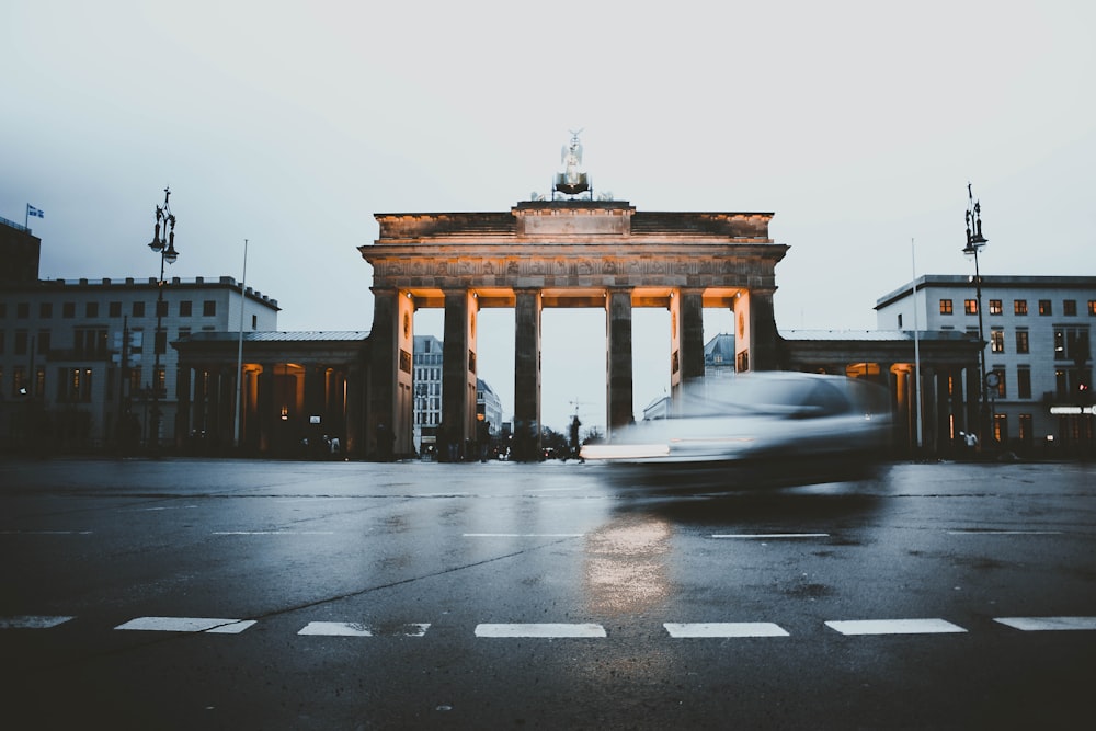 panning photo of car beside Brandenburg Gate, Germany
