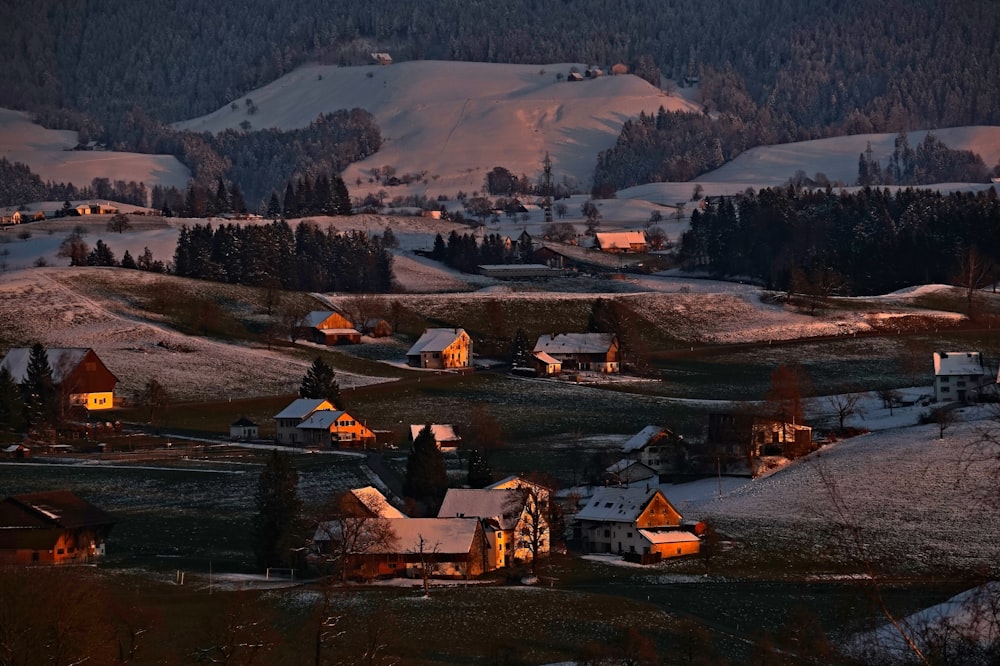 Fotografía aérea de casas cerca de montañas nevadas durante el día