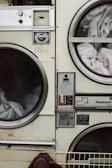 two white front-load washers filled with clothes