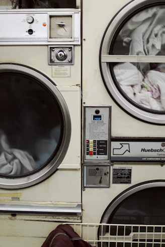 two white front-load washers filled with clothes
