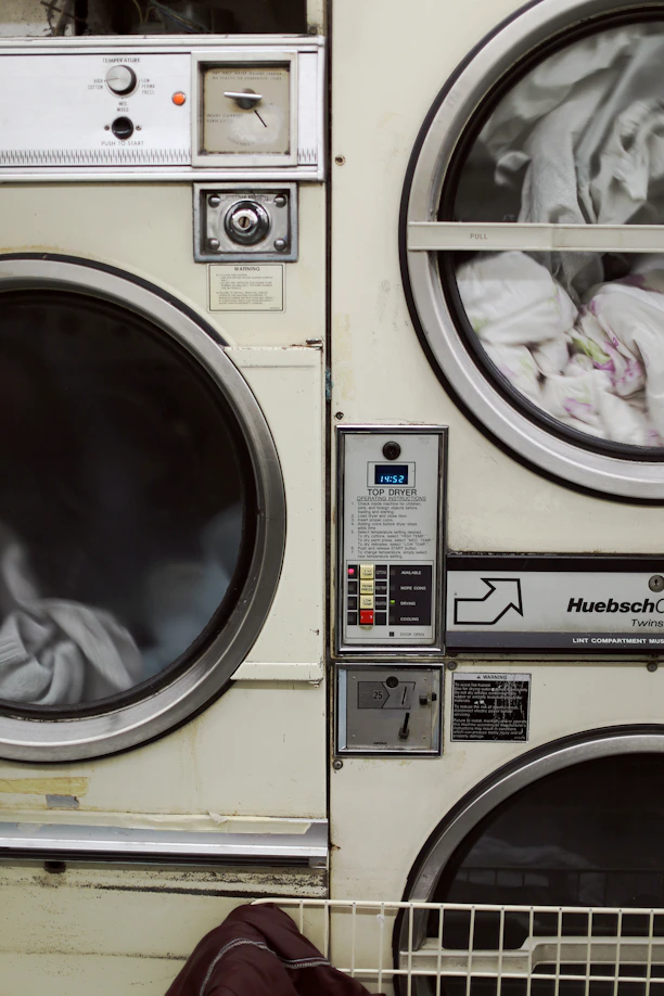 two white front-load washers filled with clothes