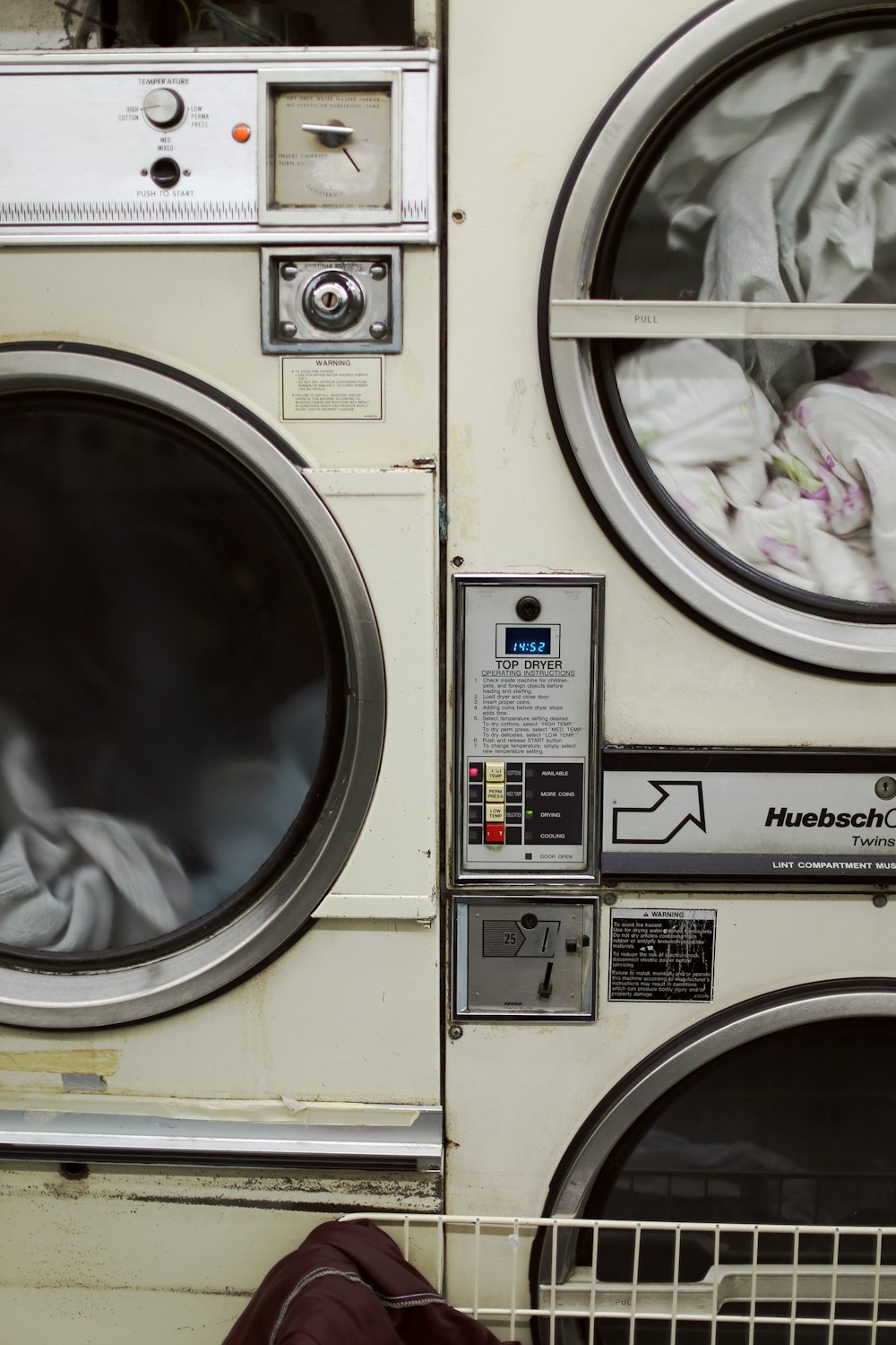 two white front-load washers filled with clothes