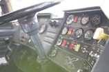 A close-up view of a vehicle dashboard with multiple gauges, switches, and indicators. A steering wheel is prominently visible, and there is branding with the word 'Eagle' and an eagle graphic. The dashboard includes dials for air pressure, fuel, and other metrics, with a variety of buttons and colored labels.