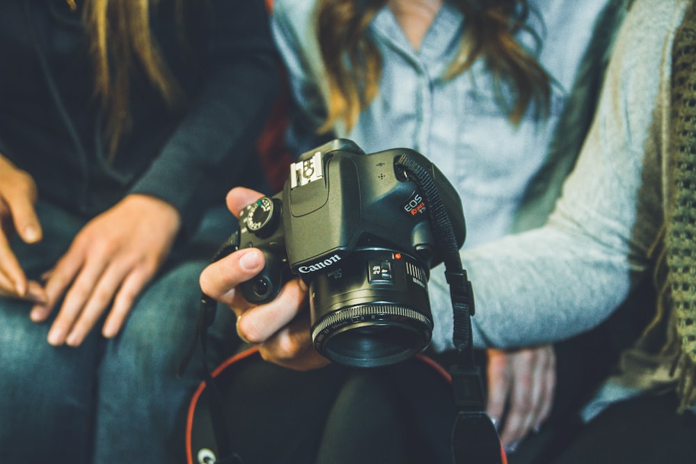 person carrying Canon DSLR camera