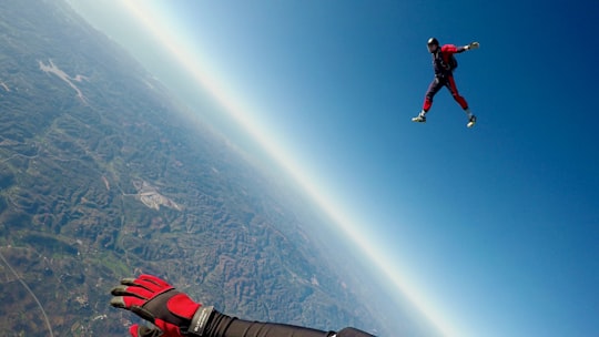 man in red and black outfit air diving in Faro Portugal