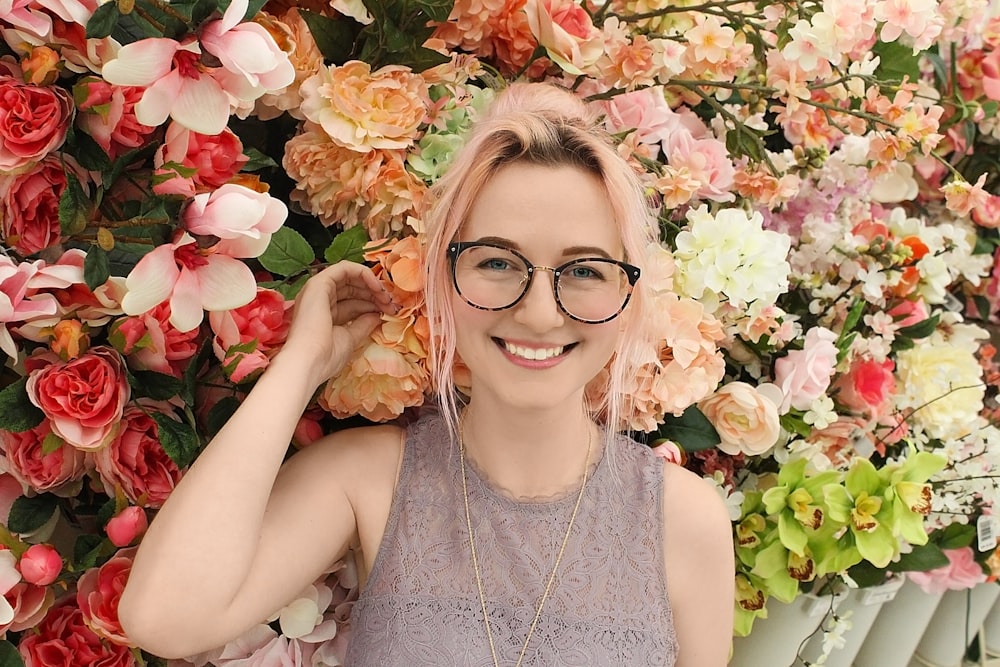 woman standing near assorted-color petaled flowers smiling