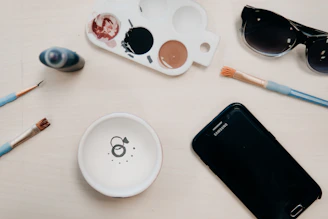 A minimalist flat lay of art supplies including pencils, brushes, and notebooks on a wooden table.