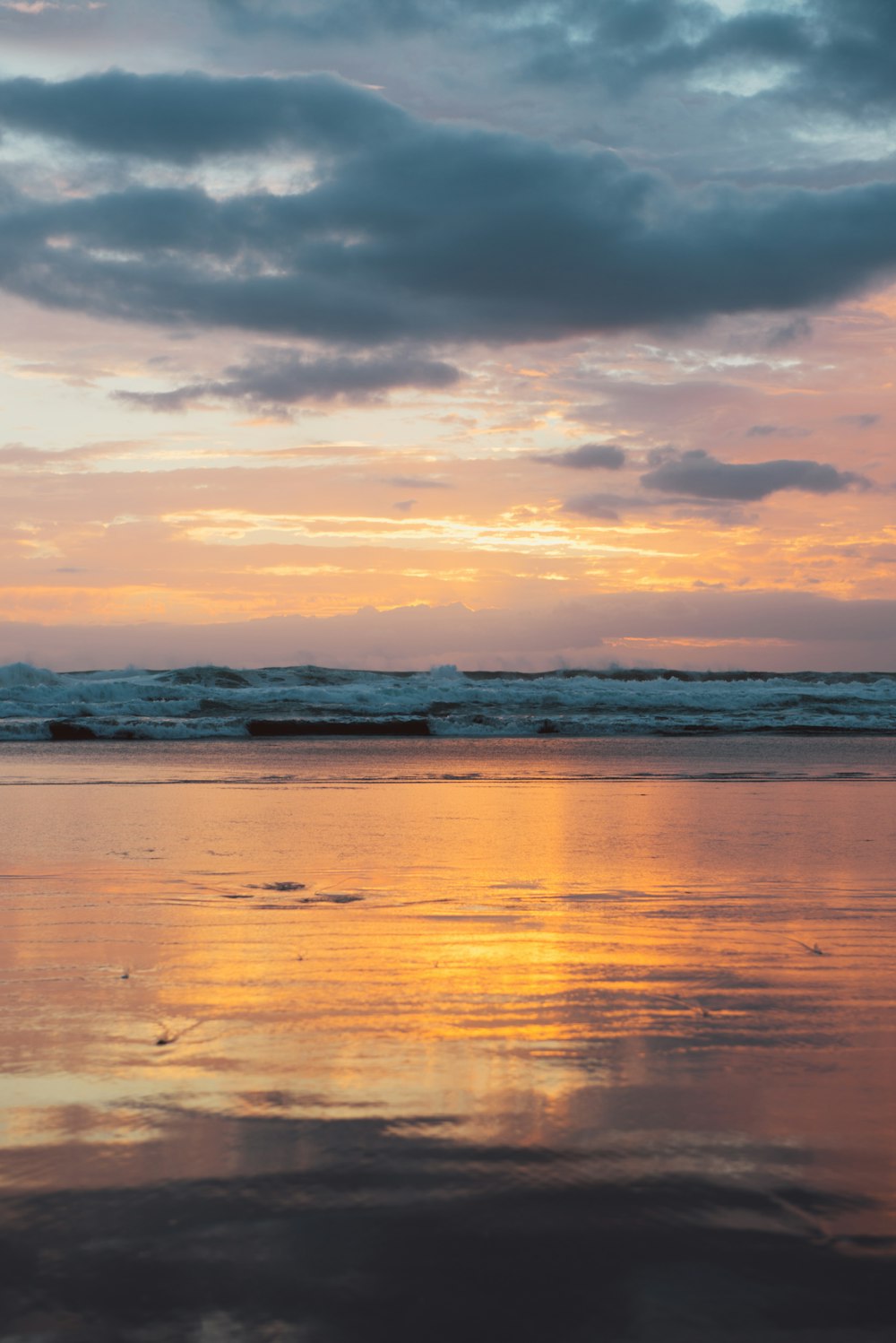 calm water under white clouds during golden hour