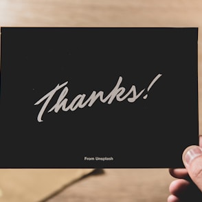 person holding Thanks card