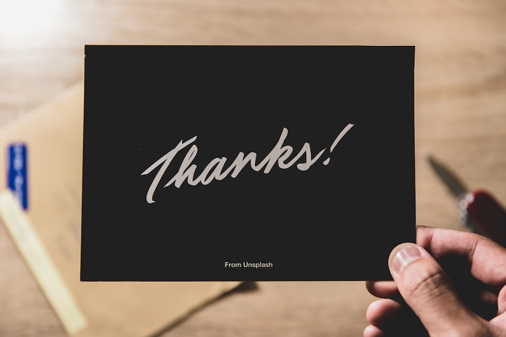 person holding Thanks card