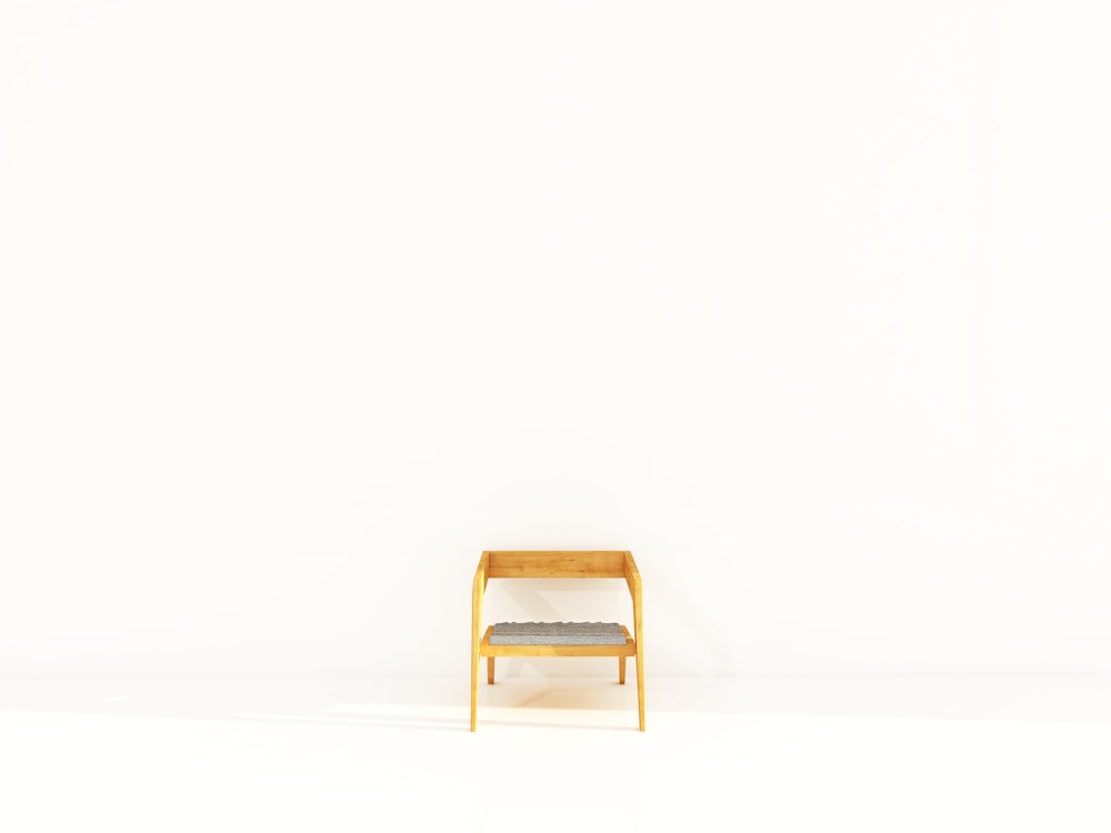 Brauner grau gepolsterter Sessel mit Holzrahmen in der Nähe einer weiß gestrichenen Wand
