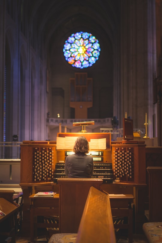 person sitting in front of church organ in Grace Cathedral United States