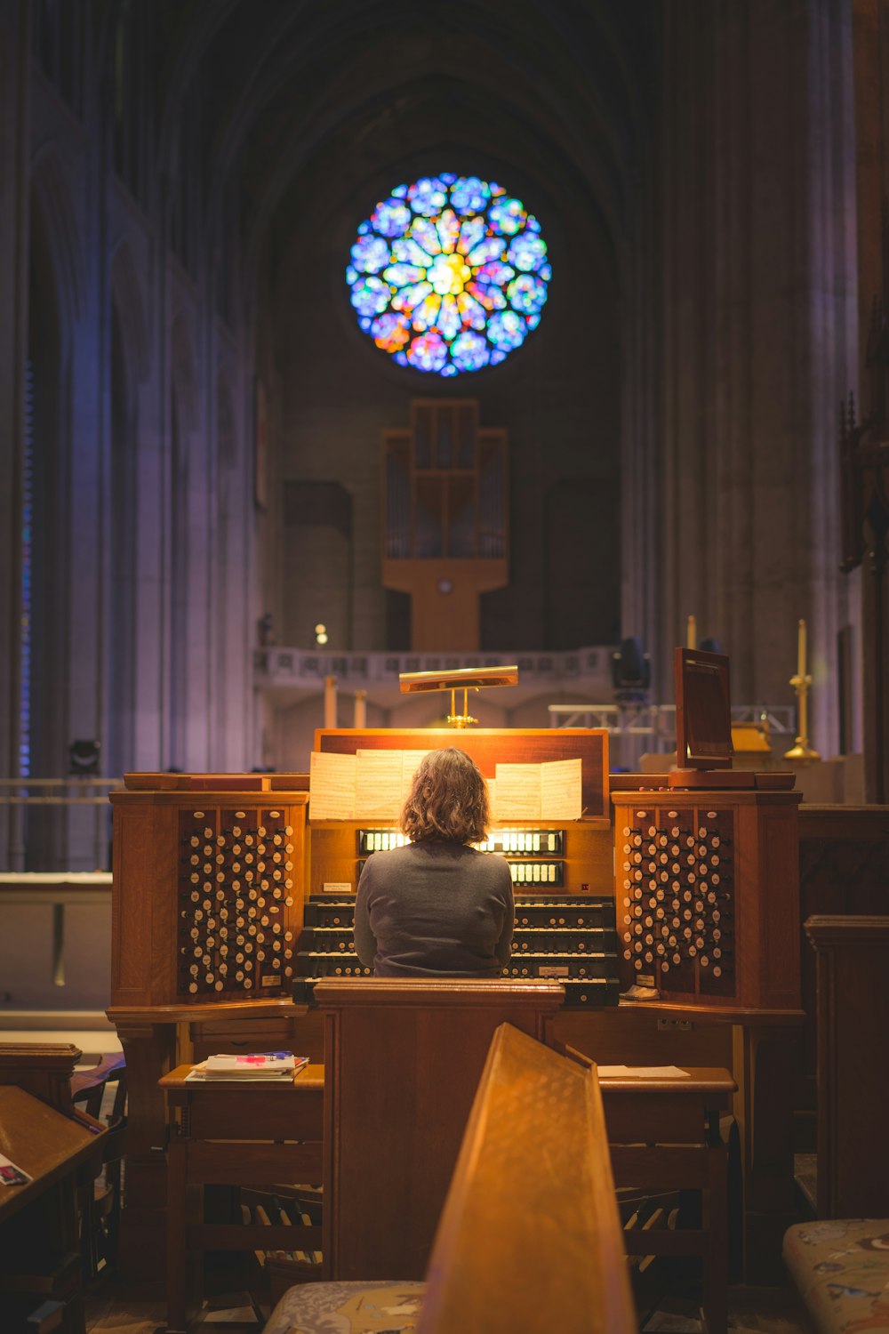person sitting in front of church organ