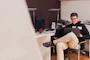 Photo of a cheerful entrepreneur working on a laptop in a cozy home office.
