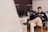 man smiling while sitting and using MacBook