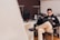 Smiling person using a laptop in a bright, clean workspace with modern decor.
