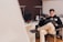 A person using a laptop in a cozy home office, managing finances online.