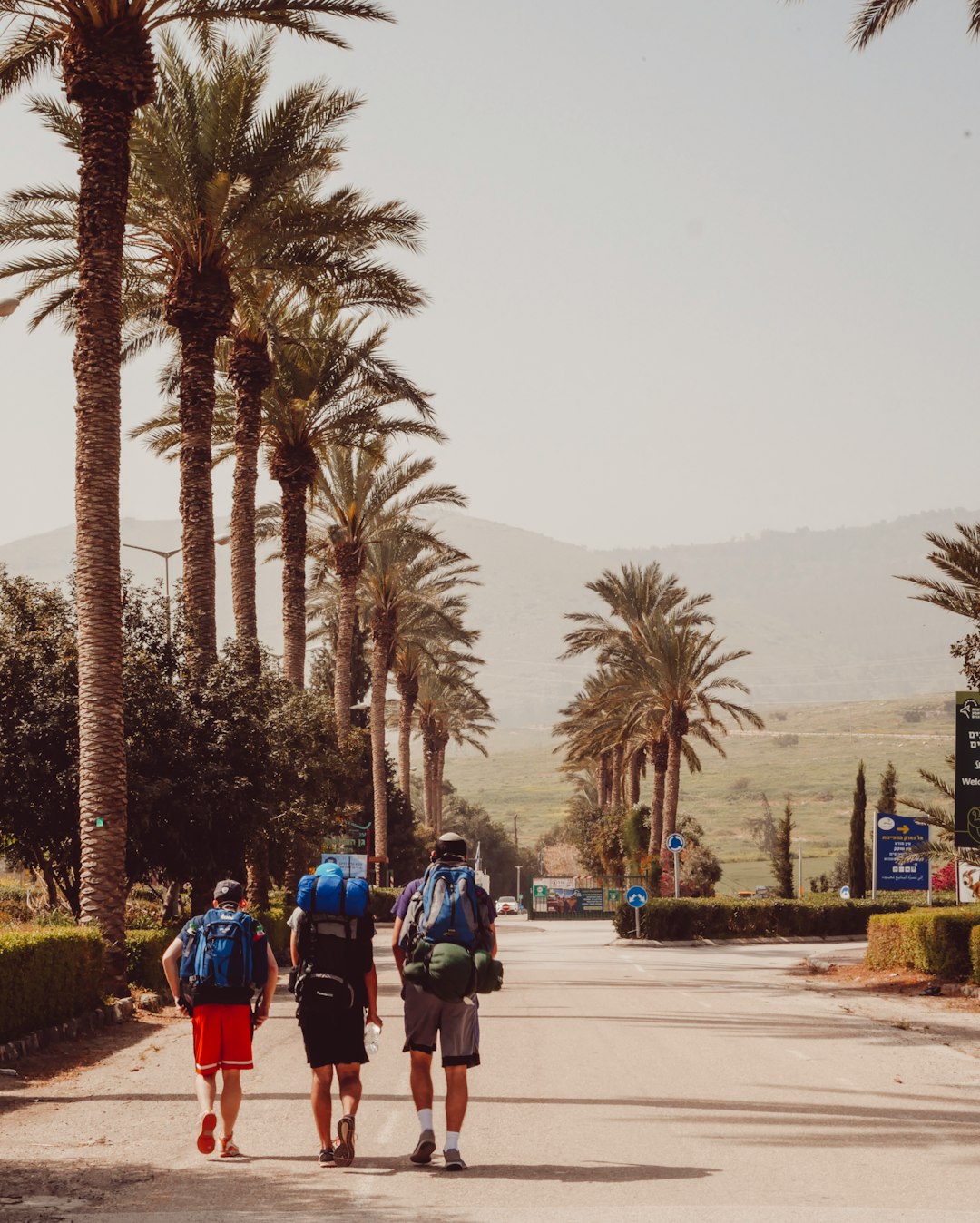 three men walking carrying backpacks