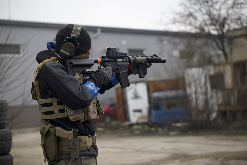 Soldat tenant un fusil d’assaut pendant la journée