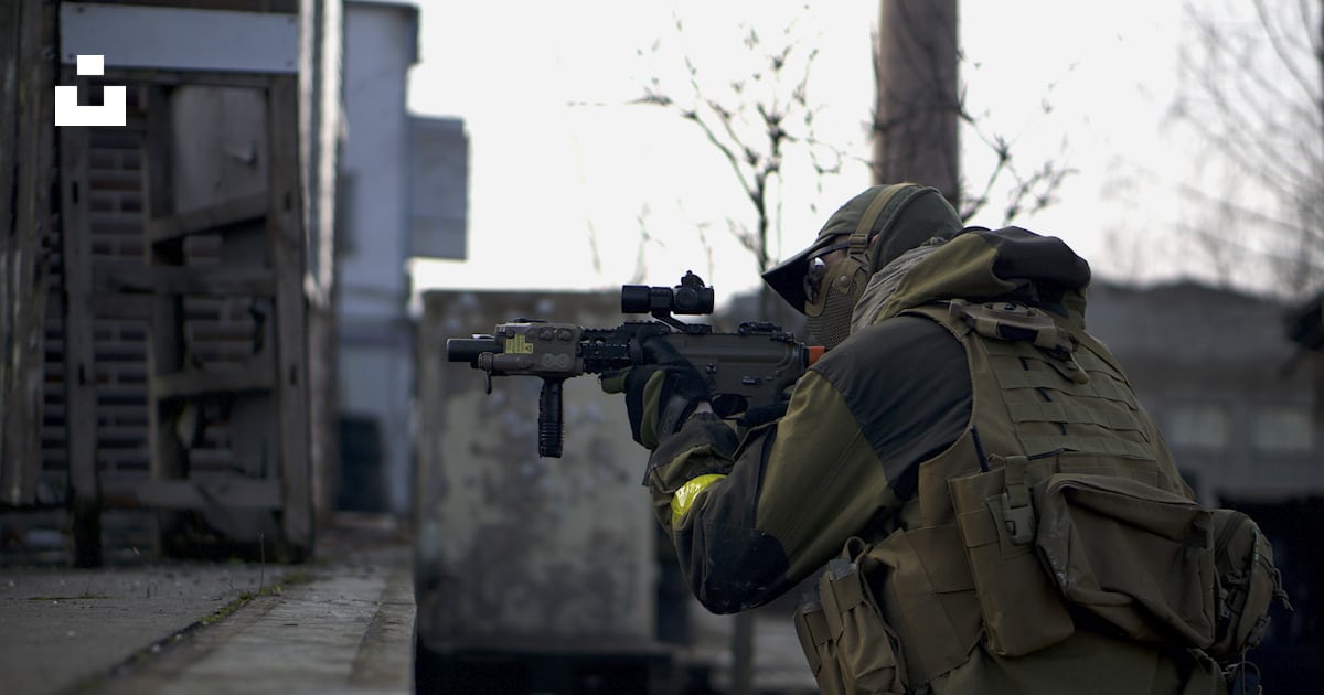 Person holding riffle near post photo – Free Weapon Image on Unsplash