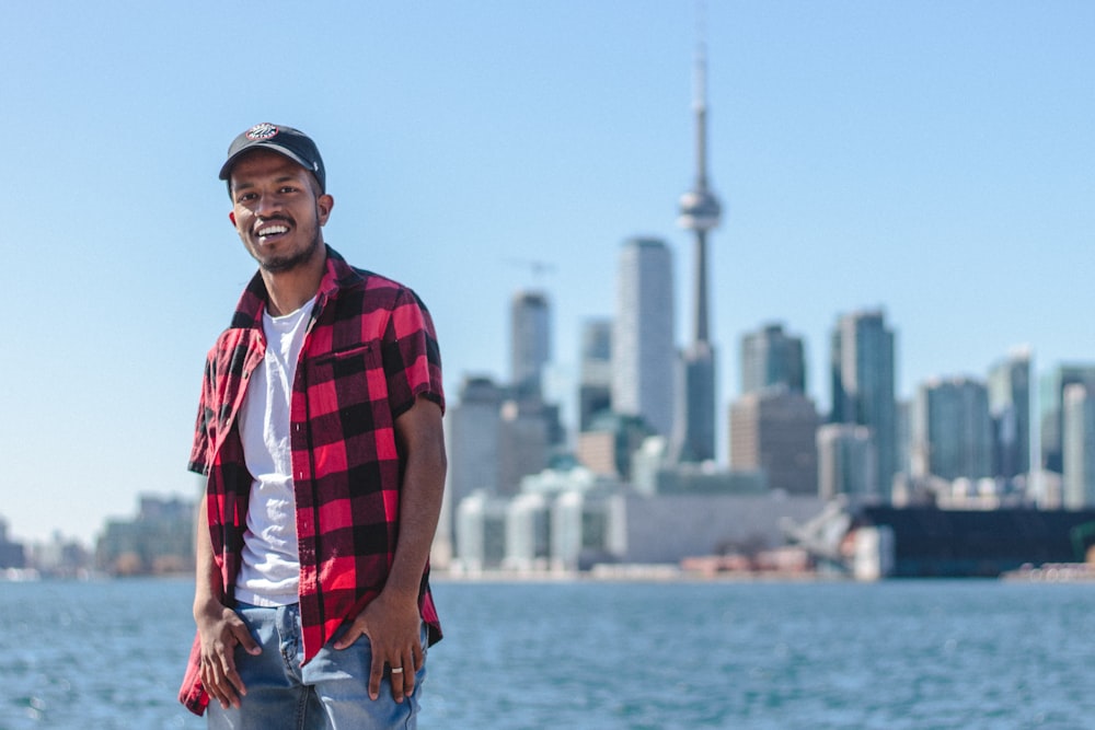 stehender Mann macht Selfie neben dem CN Tower, Kanada