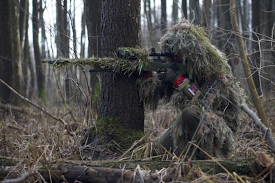 person holding green rifle shooting