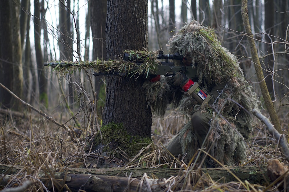 Person mit grünem Gewehr schießt