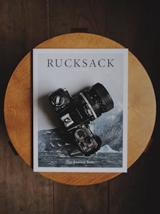black DSLR camera on Rucksack book