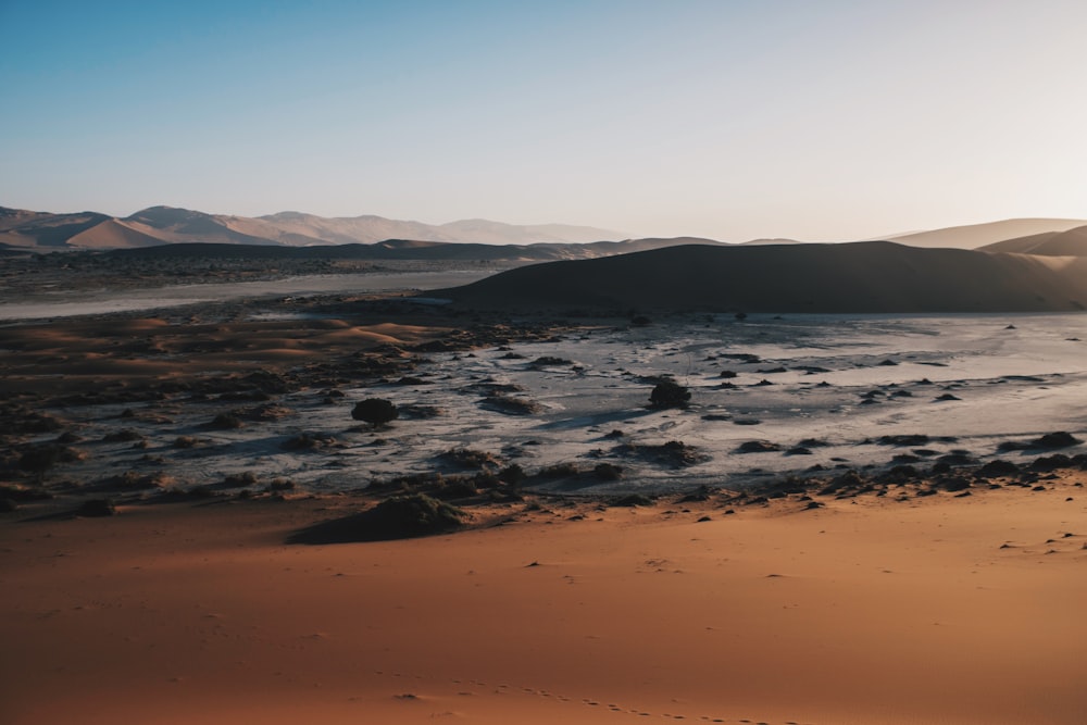 body of water near hills at daytime