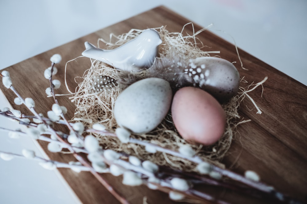 low light photography of three decorative eggs on nest